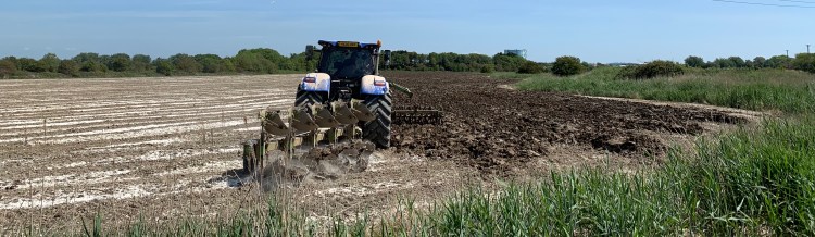 A farmer ploughing a field by tractor